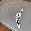 Detail of irregular metal enamel pendant necklace with black and red accents - Silver-Red-Black