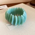 Close-up macro view of a minimalist marbled green oval resin bracelet on textured fabric - Green (43#)