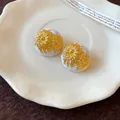 Primer plano de aretes vintage de esmalte blanco con motivos de margaritas doradas grabados - Oro-Blanco