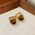 Dettaglio di orecchini vintage placcati oro con pietre occhio di tigre tonde lucide - Stile Ciondolo Nucleo Tondo (HE29421)