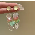 Close-up detail of silver needle geometric shell tassel earrings with colorful discs - Geometric Shell Tassel Style / Silver Post-Multicolor (White/Yellow/Pink)