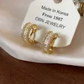Gros plan de boucles d'oreilles clips dorées 18 carats avec zircons brillants - Clip (Plaqué Or) / Pack de 1 paire / Or
