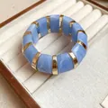 Elegant blue marble swirled resin stretch bangle with polished gold-toned metal spacers - Blue