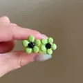 Detail view of green flower resin stud earrings with black center in forest style - 1# Flower Style / Green