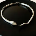 Macro view of silver snake-shaped choker with green gemstone eyes and detailed scales. - Snake Style (WN034) / Silver