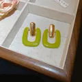 Close-up detail of lime green resin U-shaped earrings displayed in a wooden jewelry box - 20# Geometric Rectangular Lacquered Resin Style / Lime Green