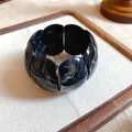 Close-up detail of black and white marbled acrylic beads on an elastic square bracelet - Marble Wide Bangle (HB4269) / Black