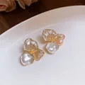 Close-up of French retro three-petal flower stud earrings with pearlescent finish - Three Petal Style (WE3033) / Gold with White