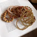Vista dettagliata dei braccialetti di perline vintage stile Maillard con legno e perle - Set 18 Bracciali Oro Marrone