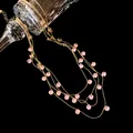 Détail d'un collier multicouche en or avec des zircons roses arrondis au style vintage chic - Or-Rose