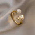 Elegant gold-tone open ring with a single pearl and abstract geometric shapes. - No. 9 Open Rings - Gold