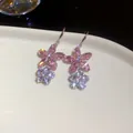 Detail of sparkling pink and white zircon flower drop earrings on a white plate. - Earring Hooks / Silver-Pink