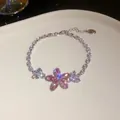 Nahaufnahme eines funkelnden rosa Zirkon-Blumenarmbands auf einem Teller - Armband / Silber-Rosa
