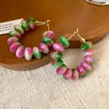 Macro detail of fashionable pink and green gradient resin hoop earrings with silver pins - Green-Purple