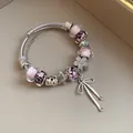 Detailed view of a sweet charm bracelet featuring pink glass beads and silver bow pendant - Silver Pink