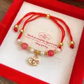 Close-up detail of red braided rope bracelet with rocking horse pendant and pink beads - Painted Enamel Rocking Horse (Pink/White Beads)