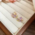 Eleganti orecchini a fiore in smalto viola con finitura dorata in un portagioie - Orecchini a clip / Un paio / Viola