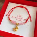 Detailed view of a red braided rope bracelet with pink glass beads and golden pony pendant - Unicorn Zodiac Horse
