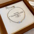 Dettaglio di un bracciale vintage malocchio con zirconi in una scatola per gioielli marrone - Bracciale Scorrevole Malocchio / Argento