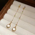 Nahaufnahme von runden Glasquasten-Ohrringen im Vintage-Stil mit vergoldeten Ketten - Weiß (HE31064) / Gold