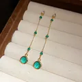 Detailansicht von vintage smaragdgrünen Glaskreis-Quastenohrringen in einer Schmuckschatulle - Grün (HE31064) / Gold