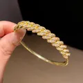 Macro view of a luxury 18k gold plated bangle featuring pavé-set clear zircons - Cuban Link Style (10)