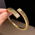 Close-up of 18k gold-plated geometric bangle with sparkling zircon square accents - Ribbed Texture Style (1)