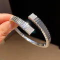 Macro detail showing sparkling zircon-paved square ends and ribbed silver metal texture. - Ribbed Square Open Style (2)
