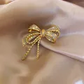 Elegant retro golden bow brooch encrusted with sparkling crystals on champagne silk - Zirconia Bow Knot Shape (HP390)