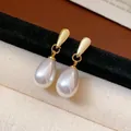 Elegante goldfarbene minimalistische Perlenohrringe in Tropfenform auf Displayständer - 75# Silberstift-Stil