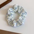 Detailed macro view of a white fabric scrunchie featuring an elegant blue floral print pattern. - Blue Floral Edge Style (15#)