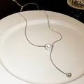 Detailed macro view of an adjustable silver snake chain necklace with a pearl tassel - Style 2 (HN3365)