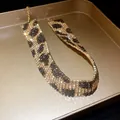Detailed view of the sparkling rhinestone leopard print pattern on wide choker necklace - Necklace / Gold