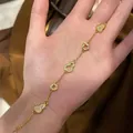 Elegant 24K gold-plated gourd and coin bracelet with zircons shown on a hand model - Gold