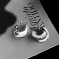 Dettaglio orecchini a perno a spirale in metallo argentato su uno sfondo grigio - Argento (HE24350)