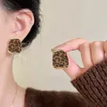 Macro detail of chic leopard print flocked stud earrings with elegant golden borders. - Trapezoid / Silver Needle / Gold