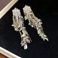 Detailed view of silver zircon tassel earrings featuring wheat ear leaf design on dark velvet - Silver