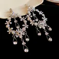 Detail shot of silver tassel earrings featuring hollow teardrop designs and rhinestones. - Silver (Silver Pin) / Silver