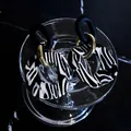 Vista detallada macro de pendientes de acrílico con patrón de cebra y elegantes tonos oro - Estilo Geométrico Vintage (HE6745) / Rayas de Cebra
