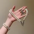 Detailed view of elegant double-layer pearl necklace, bracelet and earring set on hand - Top And Bottom / Silver