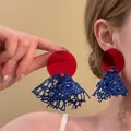 Vista detallada de pendientes con borlas rojas y azules para un look de playa verano - Estilo 1