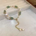 Vue détaillée d'un bracelet vintage en perles et jade vert dans un coffret à bijoux - Style Réglable Pompon Aspect Jade Vert / Vert