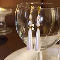 Détail de boucles d'oreilles dorées avec zircone en goutte et perle nacrée. - Tige en Argent 925 Style Goutte d'Eau / Or