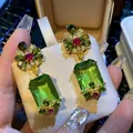 Macro view of vintage style flower earrings with emerald green rectangular drop - 35# Emerald Flower Butterfly Dangle (Silver Post)