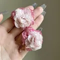 Elegant pink chiffon flower earrings held in hand featuring delicate layered fabric petals - Clip-on (51#)