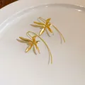 Vista dettagliata di eleganti orecchini a amo a forma di iris dorati con finitura satinata - Stile a Gancio / Oro