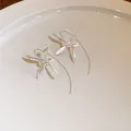 Dettaglio di eleganti orecchini vintage in argento a forma di iris con ganci curvi - Stile a Gancio / Argento