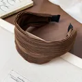 Macro detail of high top brown pleated fabric headband with elegant wide surface design - Brown