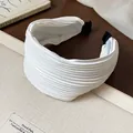Close-up of white pleated fabric wide headband with premium high-skull top design - White