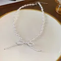 Detailed view of an elegant white pearl necklace with a delicate bow-knot pendant. - Pearl Bow Style (27#)